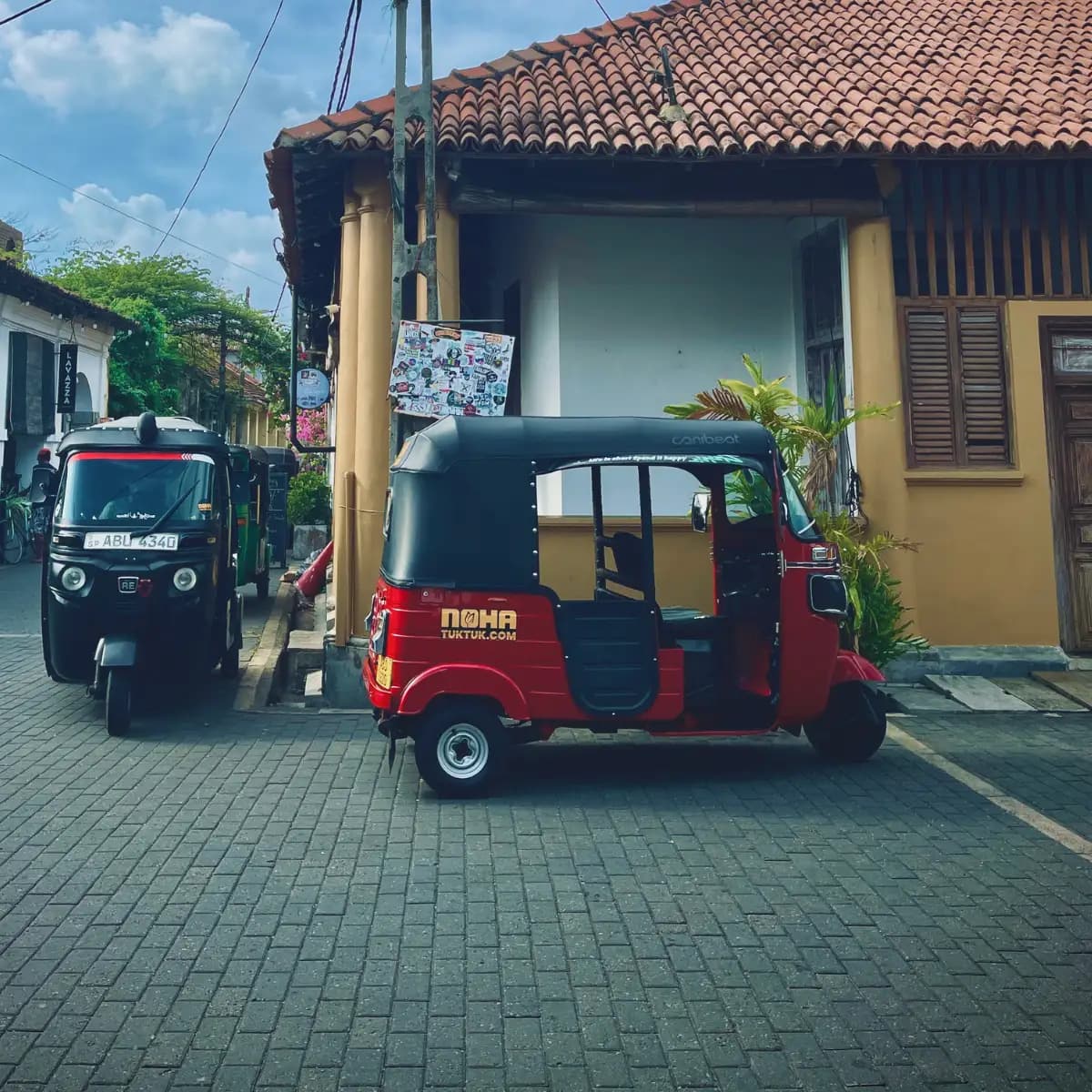 Side view of a NOHA tuk tuk parked in Galle Fort